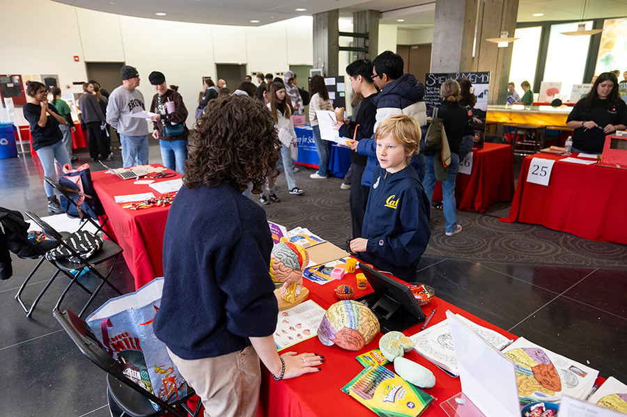 Boy stops at table to talk to researcher