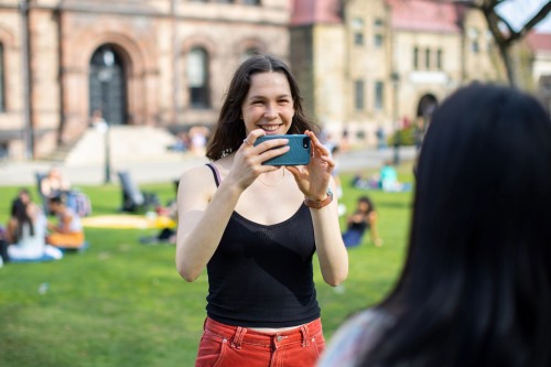 Aliza Kopans smiles while taking a photo with her smartphone